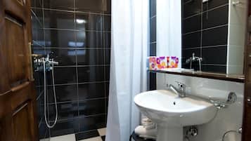 A bathroom with a shower, a sink, and a mirror.