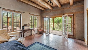 A spacious room with wooden beams, large windows, and a view of the outdoors. - Stunning Mountain Views, Hot Tub, Sweeping Portal (Santa Fe)