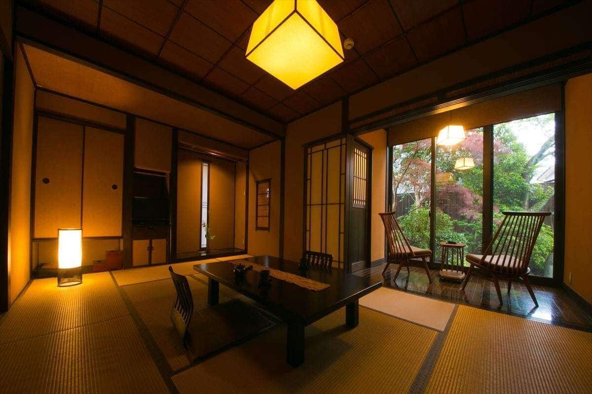 A traditional Japanese room with tatami flooring, a low table, and sliding doors.