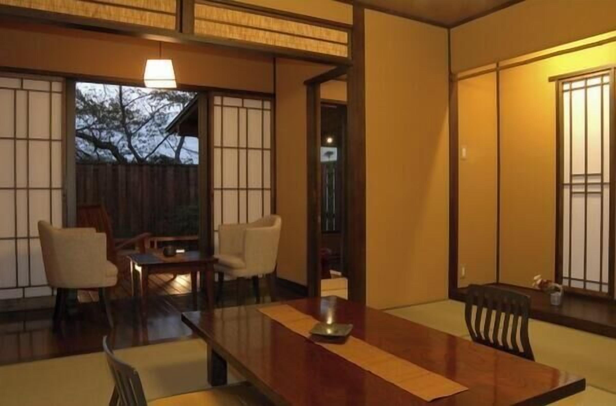 A traditional Japanese room with tatami flooring, a low table, and sliding doors.