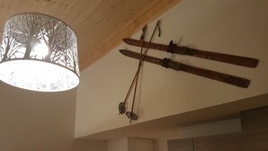 Une cuisine avec des poutres en bois, un luminaire suspendu et un porte-skis fixé au mur.