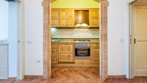 A kitchen with wooden cabinets, a stove, and a tiled backsplash.