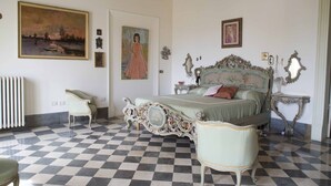 Un dormitorio con piso a cuadros, cama ornamentada y obras de arte en las paredes.