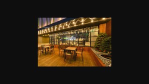 An outdoor dining area with tables and chairs, a wooden deck, and a Christmas tree. - Lifestyle S Hotel (Seoul)