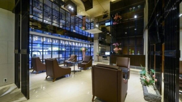 A modern lobby with seating areas, large windows, and a decorative plant arrangement. - Lifestyle S Hotel (Seoul)