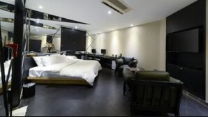 A modern hotel room with a large bed, a desk, a chair, and a flat-screen TV mounted on the wall. - Lifestyle S Hotel (Seoul)
