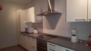 A modern kitchen with stainless steel appliances, white cabinetry, and a built-in oven. - Villa with private heated pool and jacuzzi (PLAYA BLANCA)
