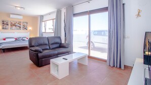 A modern living room with a sofa, a coffee table, and a bed with a headboard. - Villa with private heated pool and jacuzzi (PLAYA BLANCA)