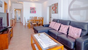 A modern living room with a sofa, coffee table, and dining area. - Villa with private heated pool and jacuzzi (PLAYA BLANCA)