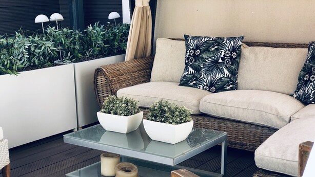 A modern outdoor seating area with a glass coffee table, wicker sofa, and potted plants. - Design apartment, with a private terrace of 140 meters 20 meters from the sea and parking (Aguilas)