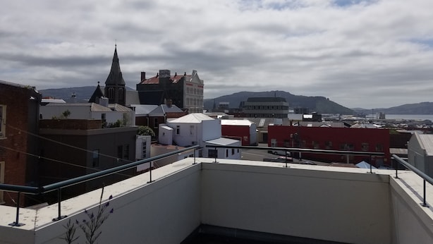 Una azotea con vistas a un pueblo, incluyendo edificios y una iglesia.