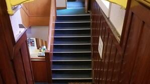 Una escalera con barandillas de madera y un rellano alfombrado.