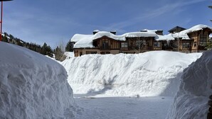 A snow-covered path leading to a lodge with multiple buildings.