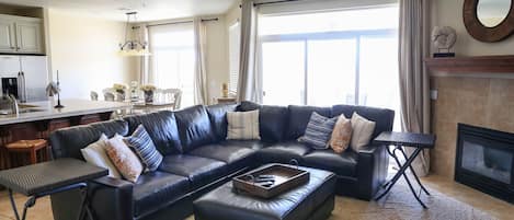 Una sala de estar moderna con un sofá modular, una mesa de centro y una chimenea.