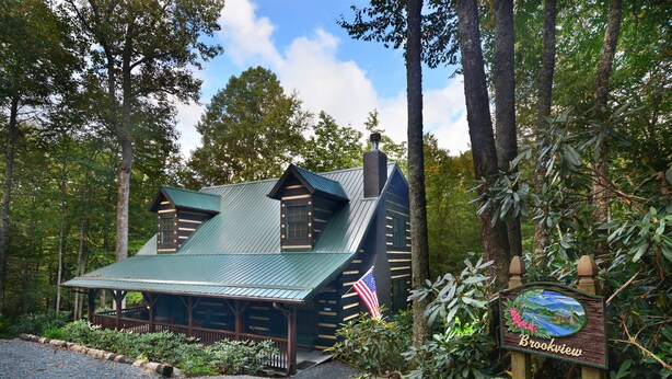 A lodge with a green roof, wooden exterior, and a sign indicating its name.