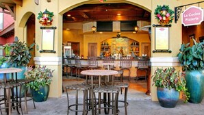 An outdoor seating area with tables and chairs, a bar with a counter, and a sign for 'La Cocina Pizzeria'. - Minutes away from all the fun at Disney Resorts!  Everything you need and want! (Orlando)