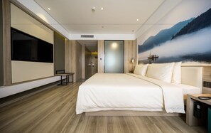 A modern hotel room with a large bed, a flat-screen TV, a desk, and a mural of a lake scene. - Atour Hotel People's Square Xiaoshan Hangzhou (Hangzhou)