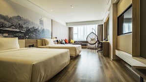 Une chambre d’hôtel avec deux lits, une grande fenêtre, un téléviseur et une fresque murale.