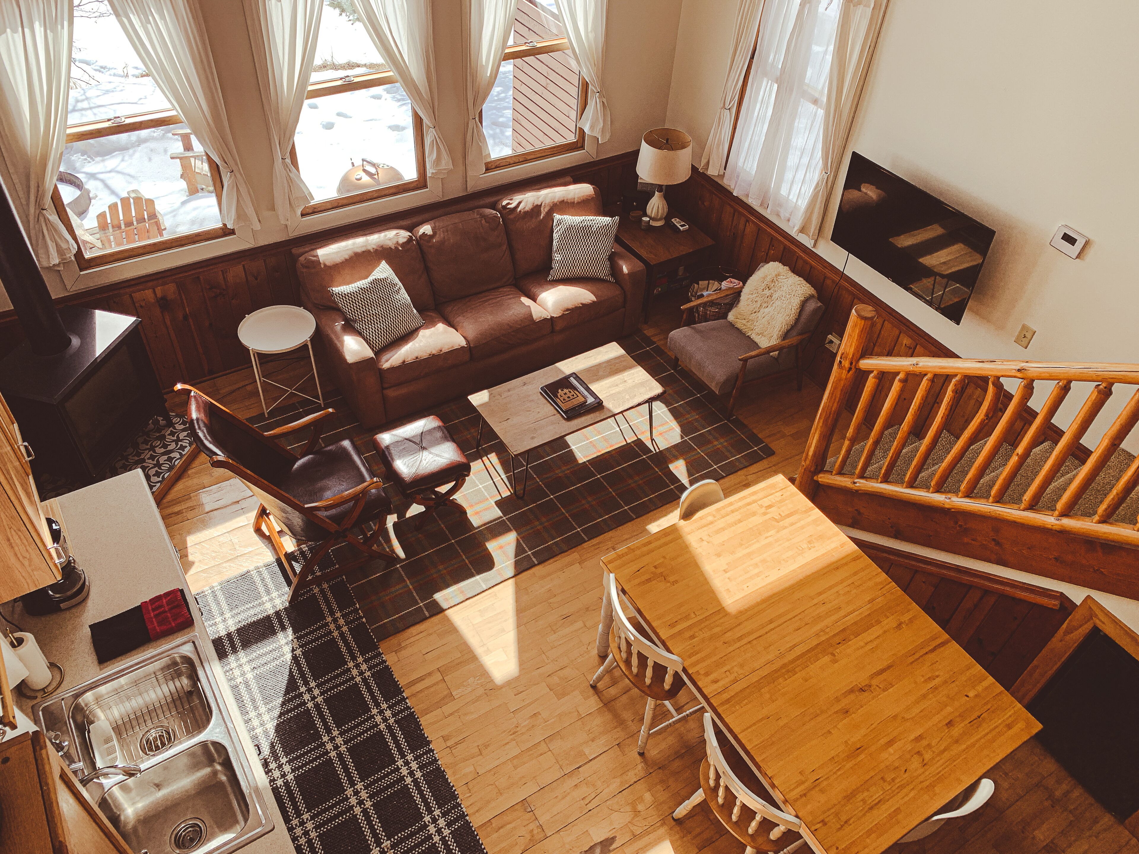 A cozy living room with a wooden dining table, a sofa, and a fireplace.