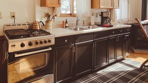 Una cocina con armarios de madera, una estufa y un lavaplatos.