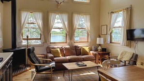 Una sala de estar acogedora con chimenea, un sofá, una mesa de centro y un televisor.
