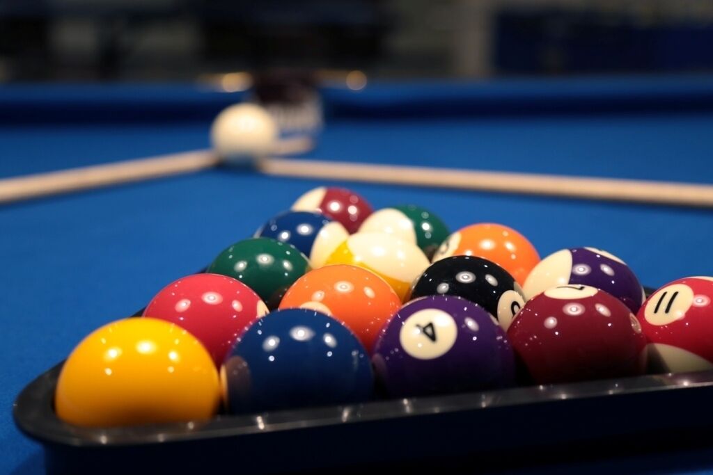 A pool table with a variety of colored billiard balls.