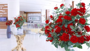 A modern lobby with a glass table and two vases of red roses. - High Castle Resort (Jeongseon)