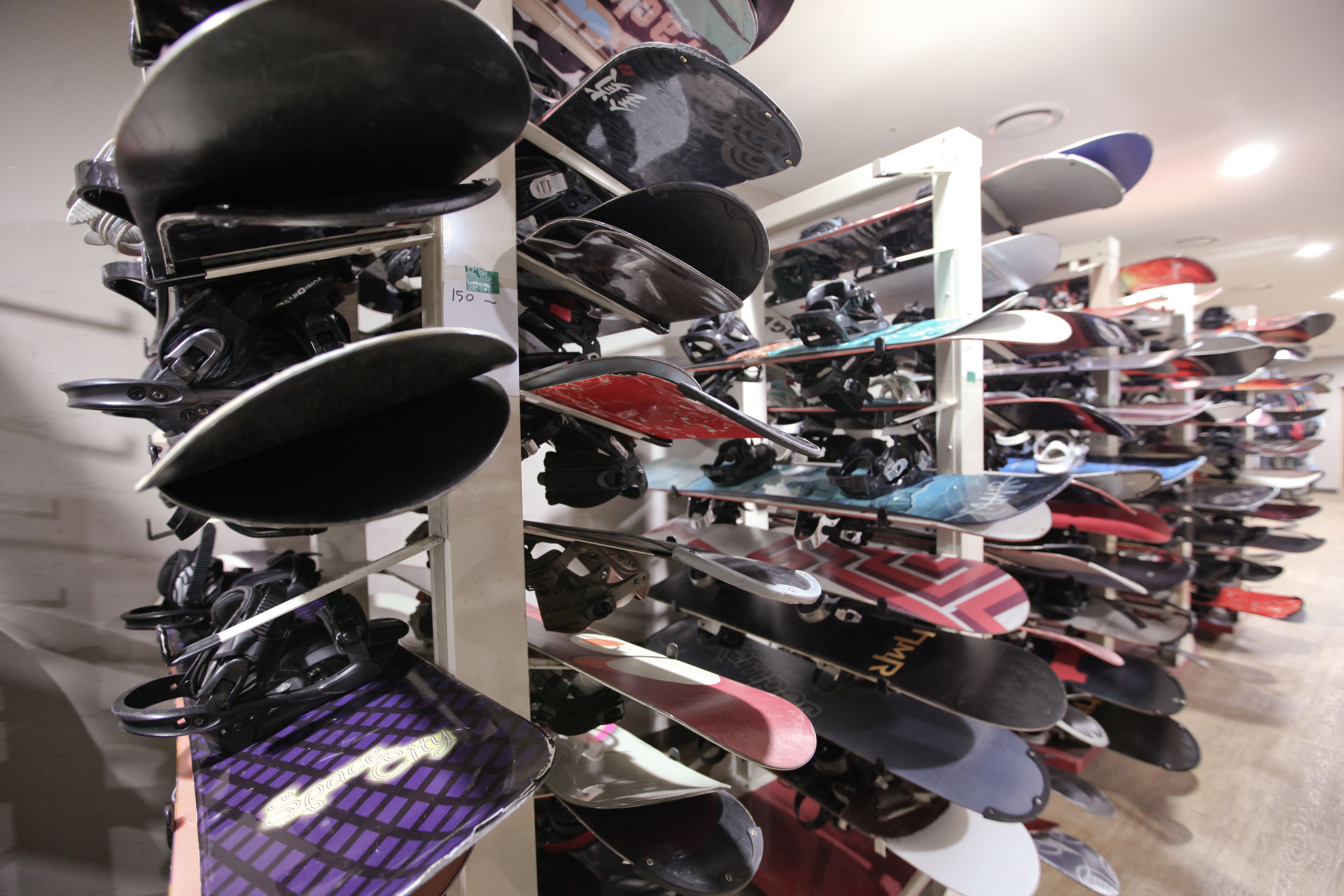 A variety of helmets and protective gear displayed on shelves in a store.