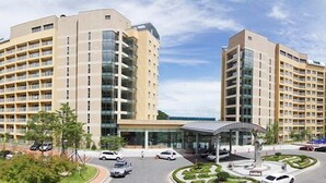 A modern hotel with multiple floors, a central courtyard, and a covered entrance. - High Castle Resort (Jeongseon)