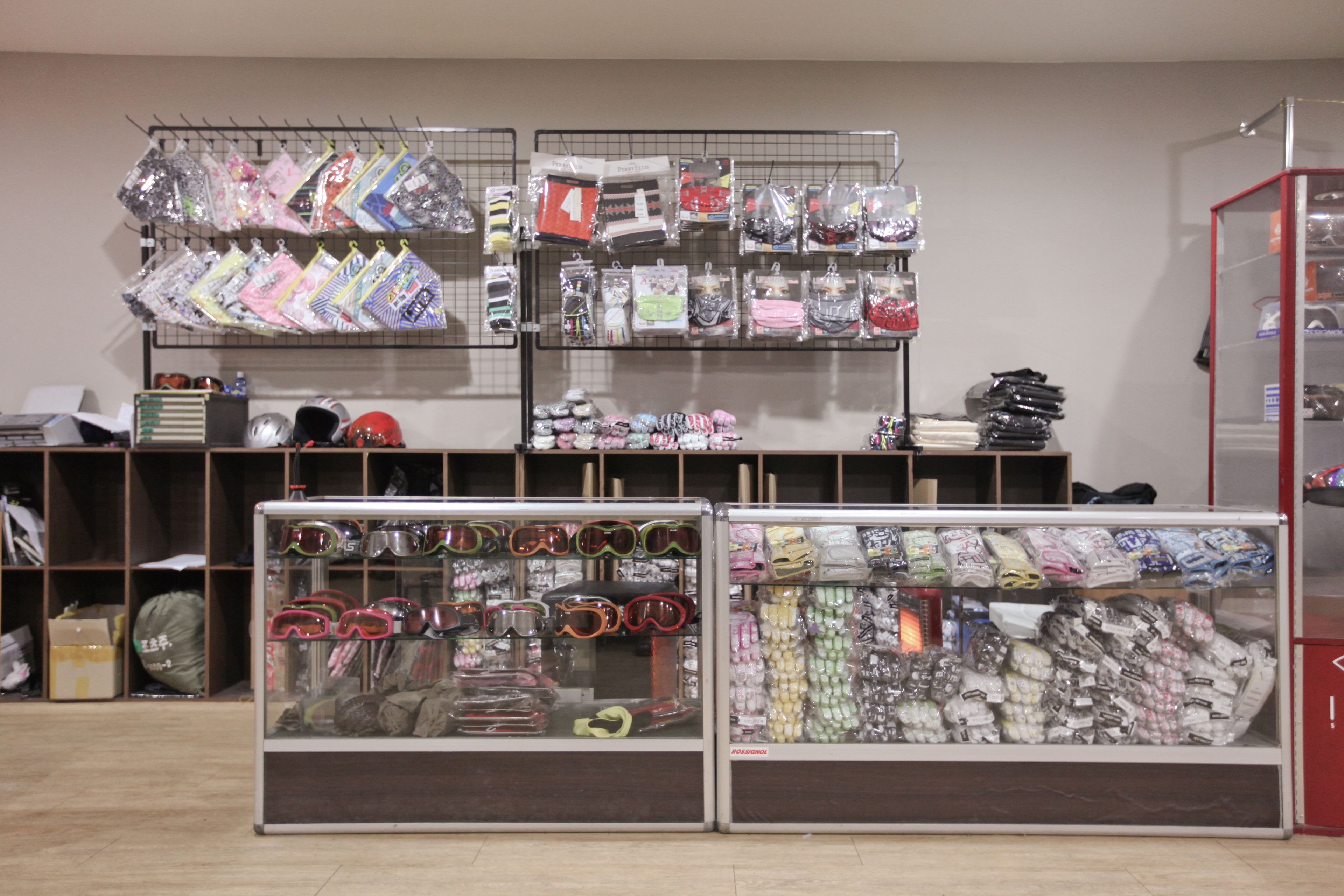 Eine Präsentation verschiedener Artikel, darunter Taschen und Accessoires, ordentlich in Regalen und Vitrinen angeordnet.