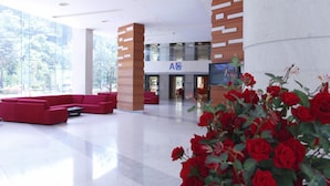 A spacious lobby with red seating, a large A5 sign, and a large window with a view of trees. - High Castle Resort (Jeongseon)