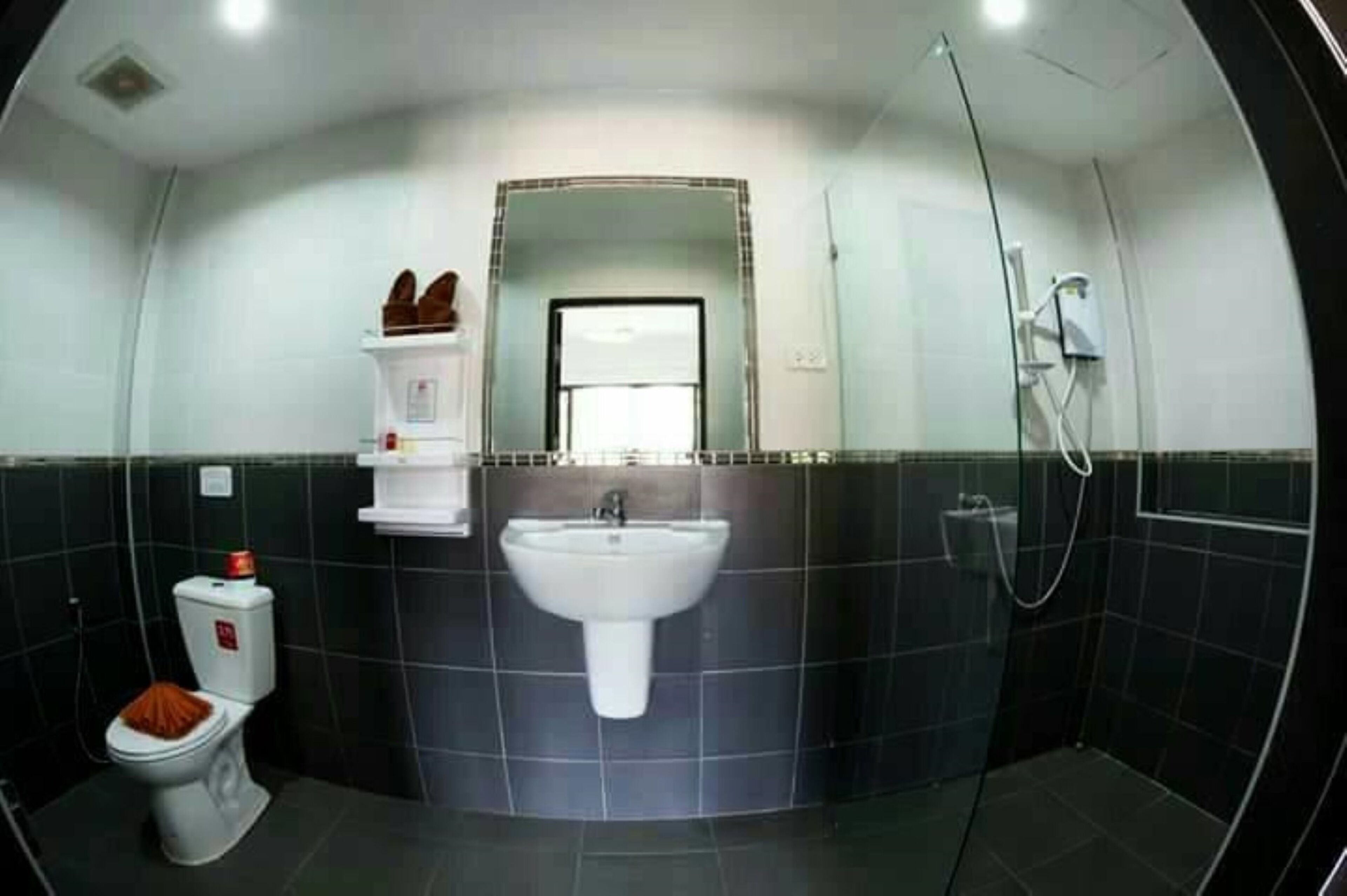 Une salle de bain avec des toilettes, un lavabo et une douche.