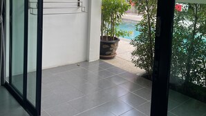 A modern interior with a glass door leading to a balcony. - Lotus Bleu Resort & Restaurant (Rawai)
