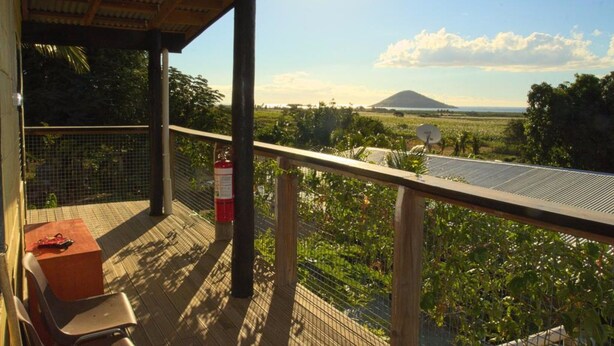 Un balcone con vista su una montagna, un estintore e un tavolo con sedie.