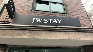 A sign for JW STAY on a building. - JW STAY in HONGDAE - Hostel (Seoul)