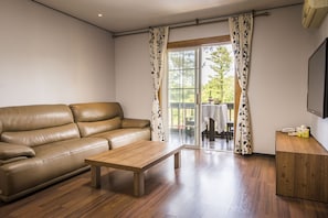 A living room with a leather sofa, a wooden coffee table, and a wooden cabinet.
