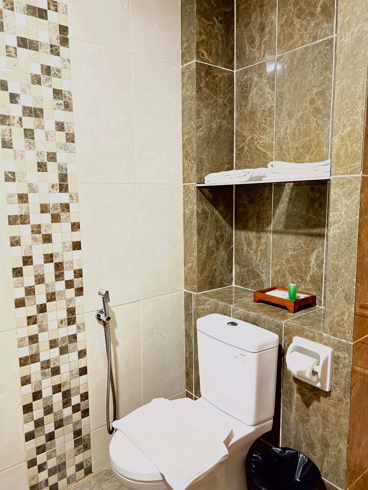 A bathroom with a toilet, a shower, and a sink.