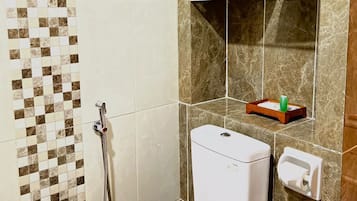Un baño con inodoro, ducha y lavabo.