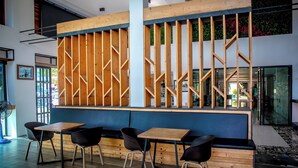 A modern interior with a wooden partition, seating area, and a view of the outdoors.