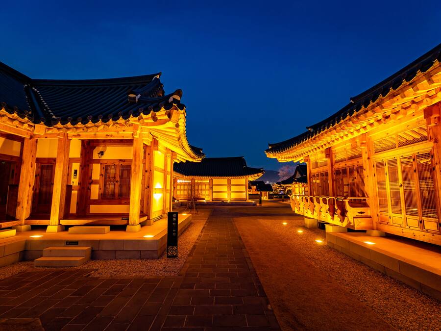 A traditional wooden building with a tiled roof and a pathway leading to the entrance.