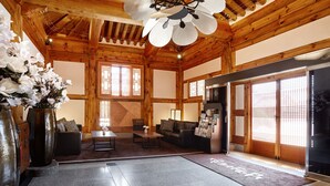 A traditional Japanese-style room with tatami flooring, a low wooden ceiling, and sliding doors.