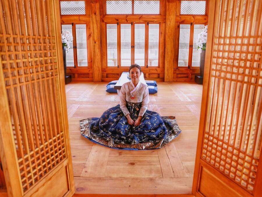 A traditional Japanese room with tatami flooring, wooden sliding doors, and a central tatami mat.