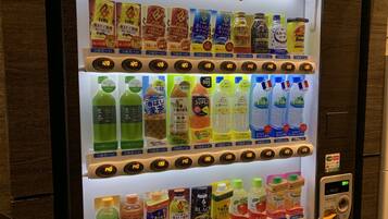Máquina expendedora con diversas bebidas y aperitivos, incluyendo productos Kirin.