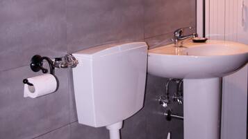 A modern bathroom with a toilet, sink, and mirror.
