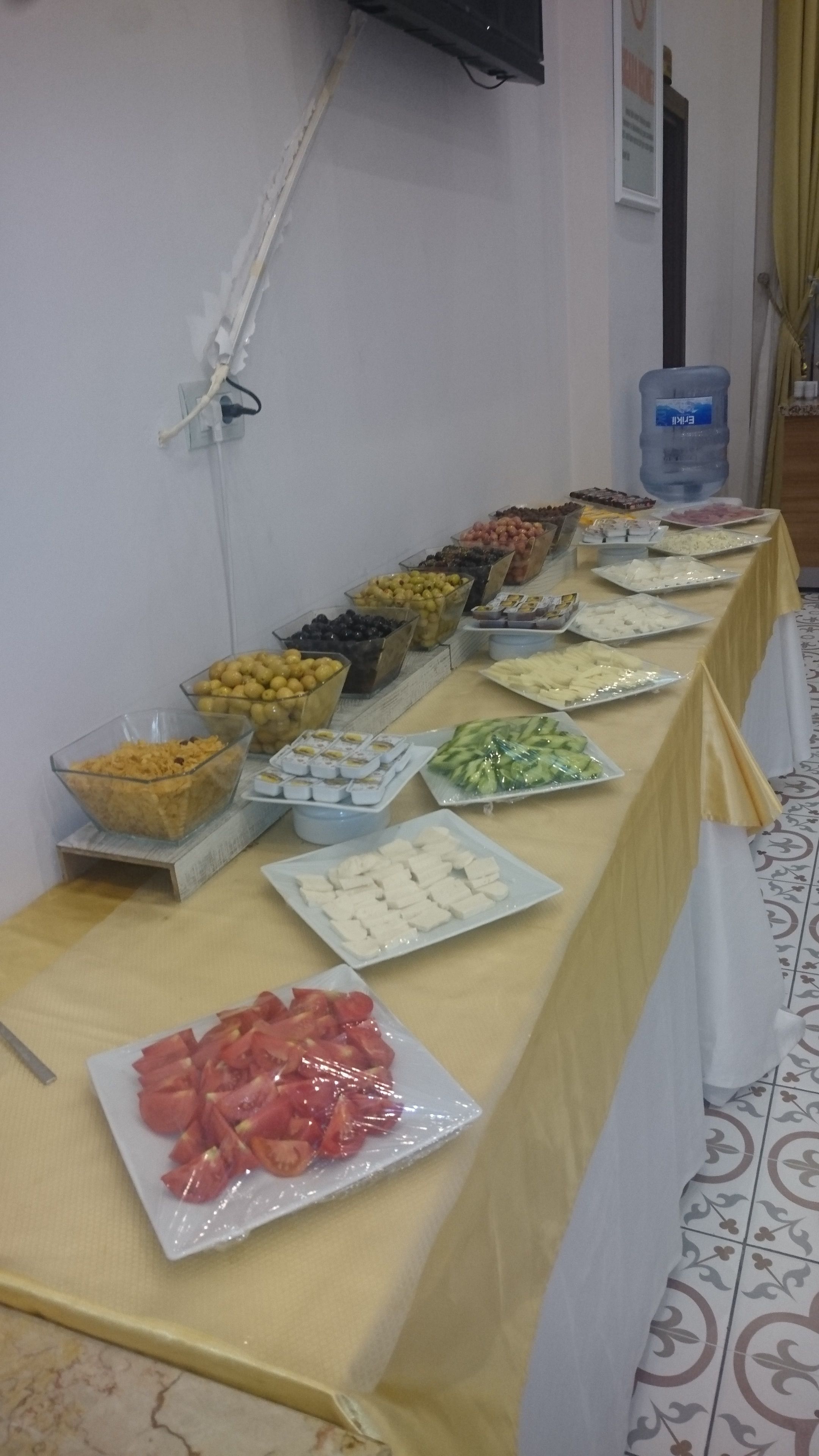 A buffet table with various food items including fruits, cheeses, and vegetables.