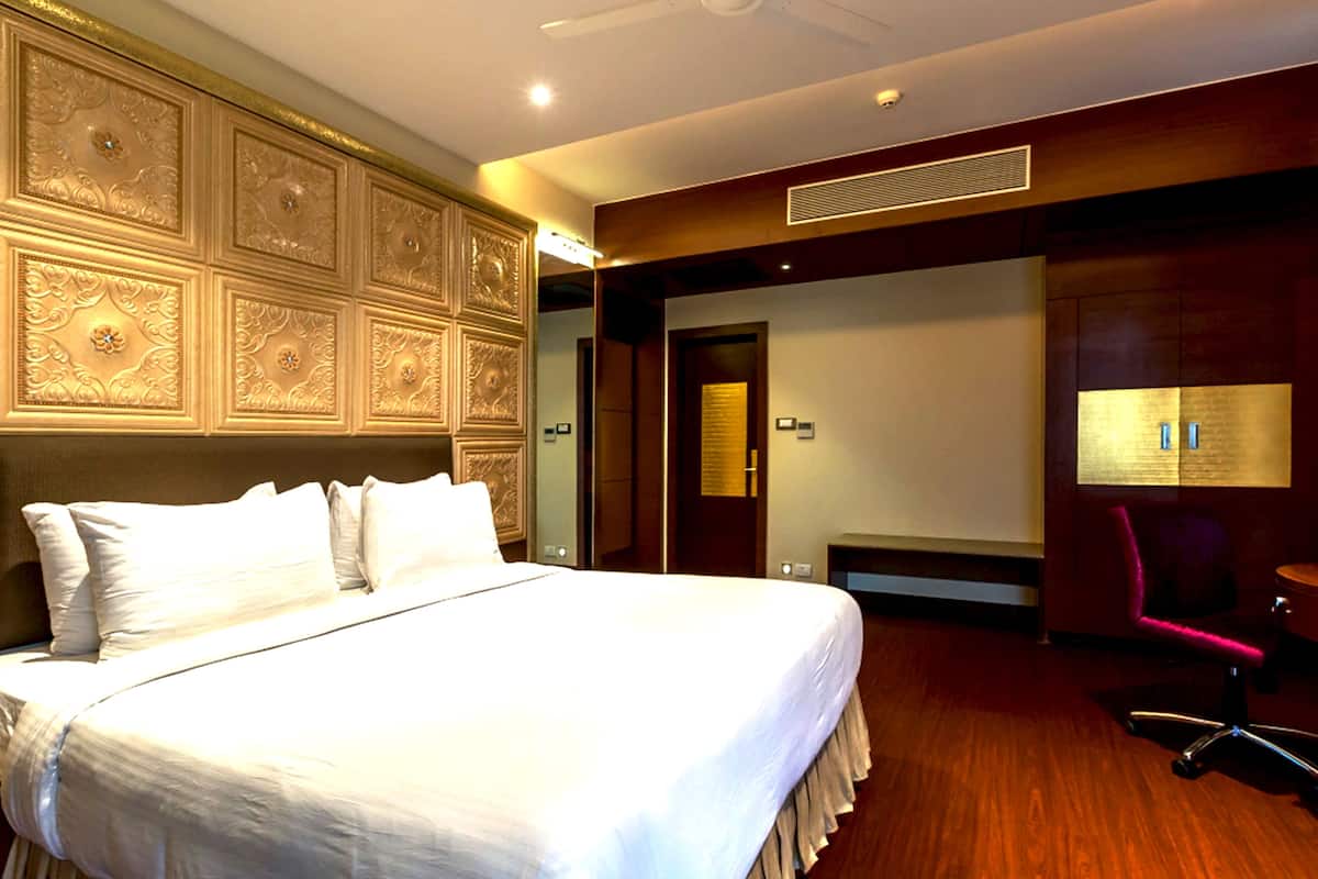 Een hotelkamer met een groot bed, een bureau, een stoel en een deur.