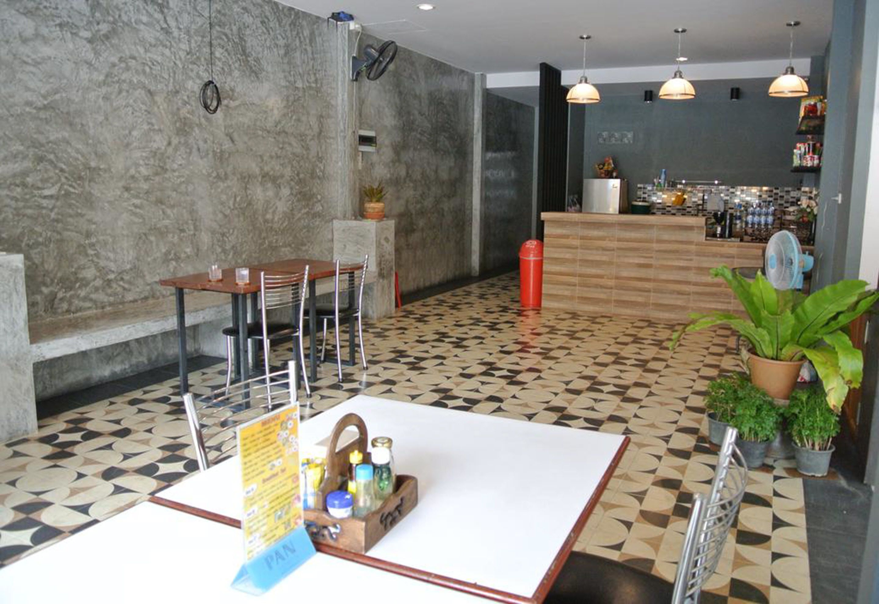 Um lobby moderno com balcão de recepção, área de estar e piso estampado.