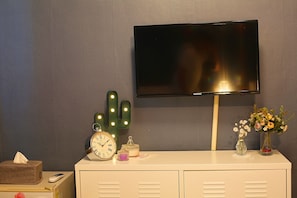 Enjoy a comfortable stay with a flat-screen TV, ample storage in the cabinet, and a stylish cactus light fixture.