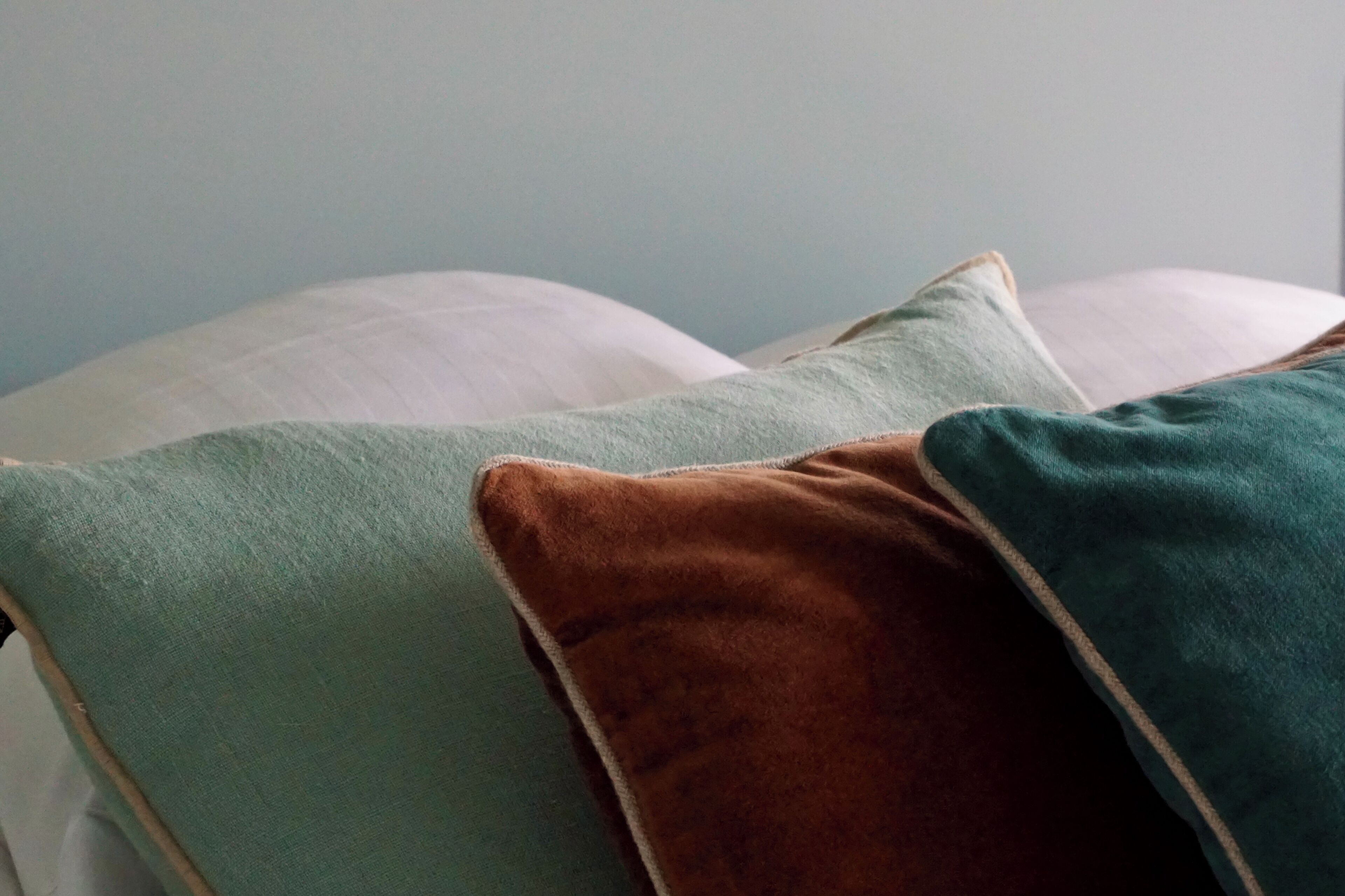 Una cama con almohadas de varios colores.