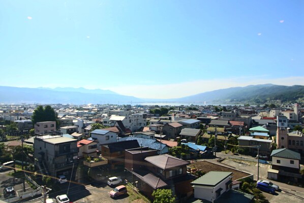 A residential area with houses, a parking lot, and mountains in the background.